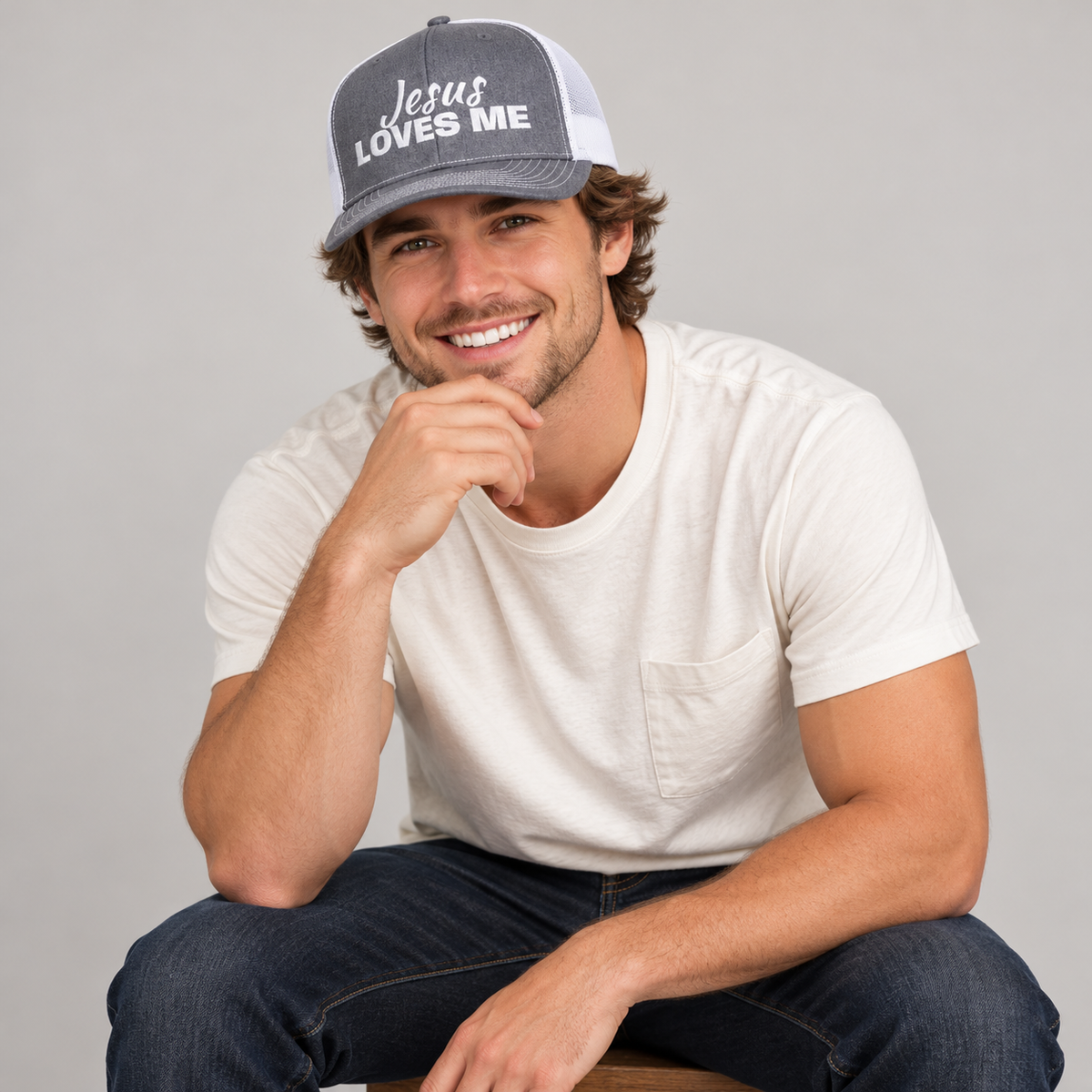 Solo smiling model wearing Jesus Loves Me Christian Snapback Trucker Cap, Heather Grey / White
