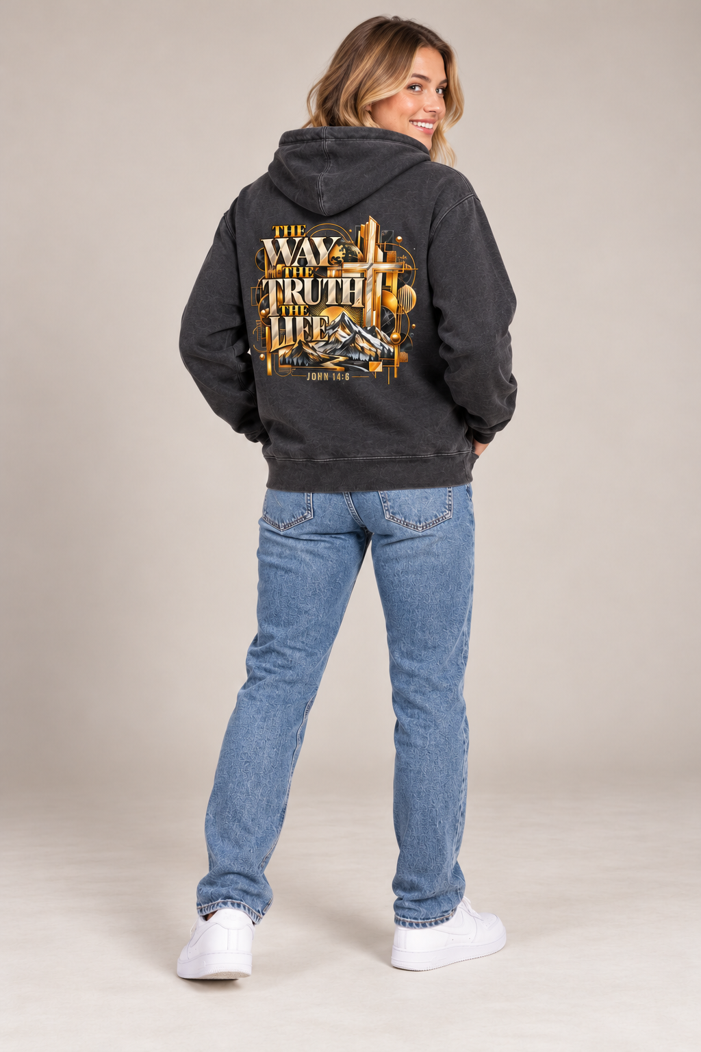 Smiling female model wearing Pigment Black Jesus hoodie, back artwork visible